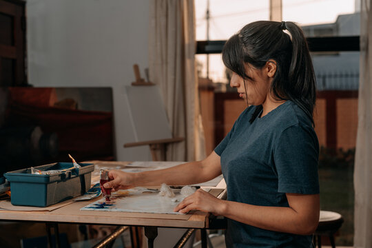 Latin woman preparing color palette for painting