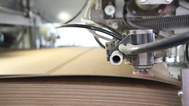 Close up detail of cartographic industrial machinery at work in a production line, conveyor belts are visible, no people are present.