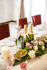 Bottles of champagne and flowers on the wedding table