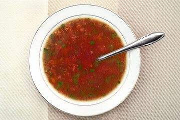 Homemade tomato soup with parsley leaves in the white plate. Top view. Healthy diet concept. 