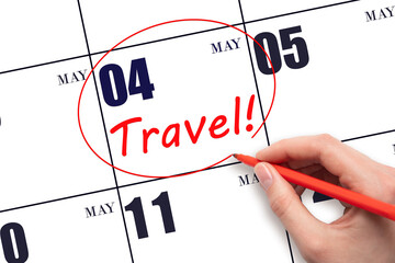 Hand drawing a red circle and writing the text TRAVEL on the calendar date 4 May. Travel planning.