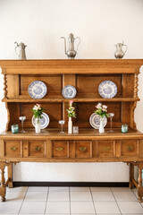 Old wooden cupboard served with flowers and plates