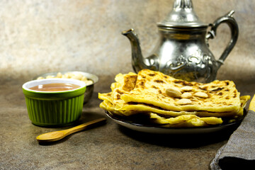 Traditional Handmade Algerian pancakes named rghaif or msemen with honey and almond and arabic teapot