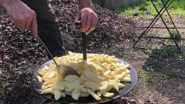 Sliced raw potatoes, roasted in large grill