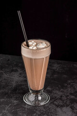 cocoa drink decorated with funny cookies on a dark background