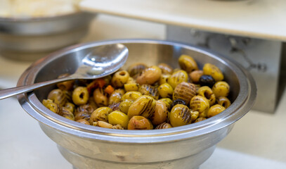 Closeup of grilled marinated green olives in bowl on table