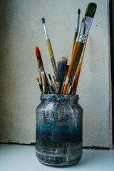 brushes in a glass, artist's tools, jar of paint brushes