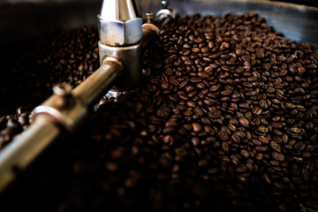 fresh coffee beans and roasted spinning cover professional machine close up photo blur and dark