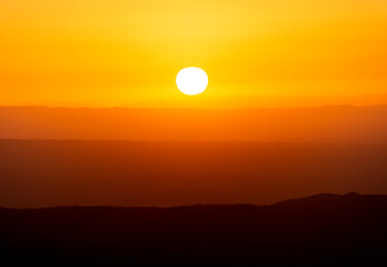 Fototapeta premium View of Mountains Ridges Layers with White Sun at Sunset Time in the Sierras de Cordoba,Argentina
