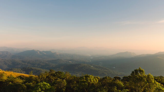 Cardamom Hills Under Clear Sky With Mist On Horizon At Sunset In Thekkady, India.