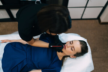 Master do permanent makeup lips procedure of girl