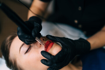 Master do permanent makeup lips procedure of girl