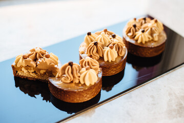 Shortbread tartlets with salted caramel and nuts. Sweet chocolate cakes. Modern mini desserts for candy bars, parties. Selective focus