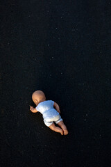 baby doll lying on black street