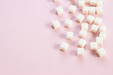 Refined sugar on pink background.Cubes of sweet and white sugar