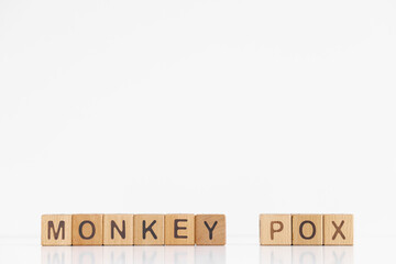 Monkey pox word is written on wooden cubes on a white background. Closeup of wooden elements