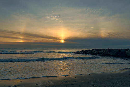 Sunrise from the beach with a breakwater