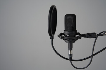 Black studio condenser microphone with pop up filter, isolated on grey background