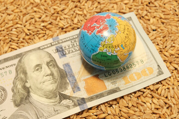 Wheat background with globe and money, one hundred dollars. Export, import, sanctions, impact of...