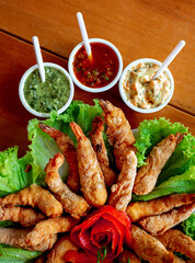 breaded shrimp with different sauces, typical Brazilian snack, seafood dish