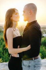 Man and woman laughing at sunset. Loving couple at sunset