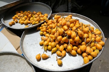 Fruits loquat (Eriobotrya japonica) are laying on big metal plates in market stall in Amman, Jordan