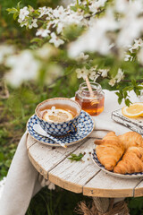 Afternoon tea party in blossom garden. Vertical