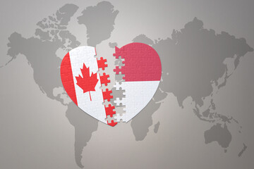 puzzle heart with the national flag of canada and indonesia on a world map background.Concept.