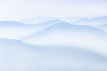 Fototapeta na wymiar View of distant mountains layers range in morning mist. Meditation and zen landscape.