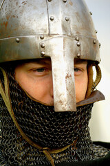 Close-up portrait of a young knight or warrior face with chainmail and nasal helmet