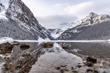 Obraz premium Lake Louise, Alberta, Canada - Incredible mountain scenery in winter time with reflection of trees in water below. 