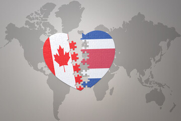 puzzle heart with the national flag of canada and costa rica on a world map background.Concept.