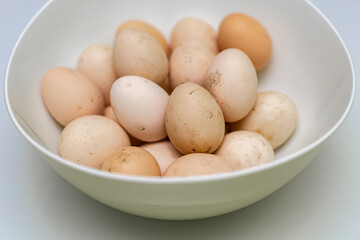 fresh unwashed rustic eggs lie in a deep bowl