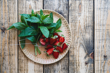 Fototapeta na wymiar Fresh organic local herb and berry fruit. Sliced strawberries and mint