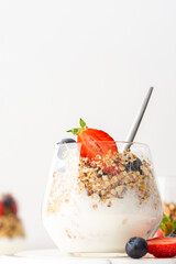 Homemade granola with almonds in a glass with yogurt, fresh strawberries and blueberries, delicious healthy breakfast