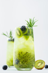 Refreshing drink with kiwi smoothie, summer sweet fruit juice with blueberries and rosemary