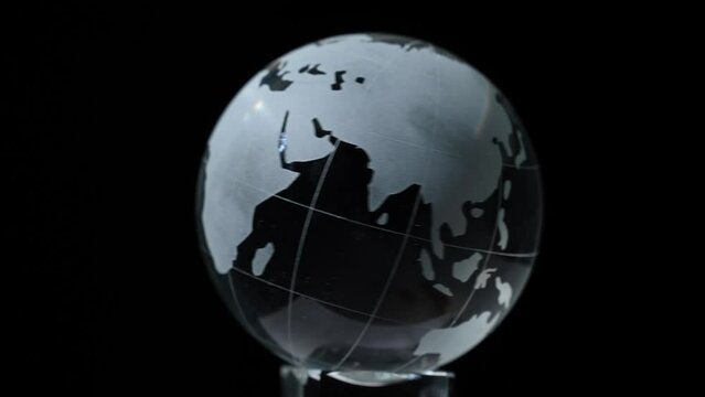 The crystal model of the globe rotates on a black background.