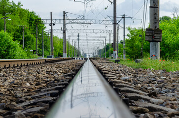 The railway goes into the distance. Reflection in the rail.