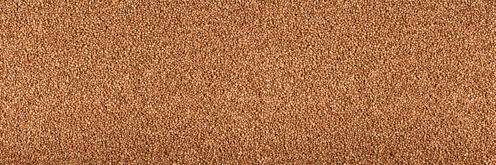 Texture of buckwheat. Background for dry buckwheat design. Large size for banner printing or packaging. Top view of evenly scattered buckwheat groats.
