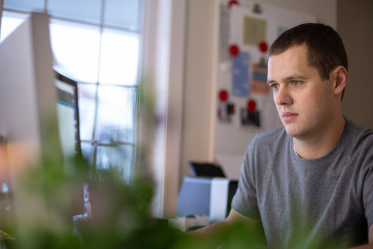 View Of Young Man Working On Computer At Home