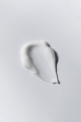  A smear of white skin cream on a white background. Cosmetic texture.