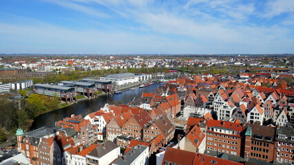 Fototapeta na wymiar Blick vom Turm der Kirche St. Petri auf Lübeck mit roten Dächern und Fluss Trave unter blauem Himmel