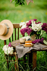 Bouquet of white and purple lilac flowers on a wooden table. Summer outdoor recreation, warm weather.