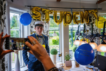 Young student at home, celebration of completion of upper secondary school in Sweden.