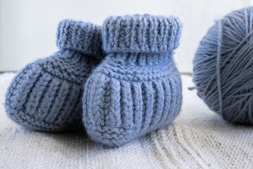 Fototapeta na wymiar Knitted socks for newborns and ball of thread. Concept of handmade knitted clothes for babies. 