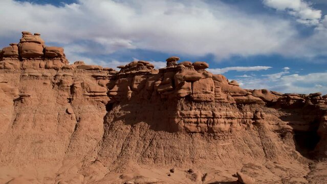 Cinematic red desert landscape with high rocky tower of sandstone cliff. Aerial view. Drone 4K footage. Utah, US.