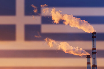 Against the background of the flag of Greece, smoke is emitted from the chimneys of the enterprise, polluting the air.