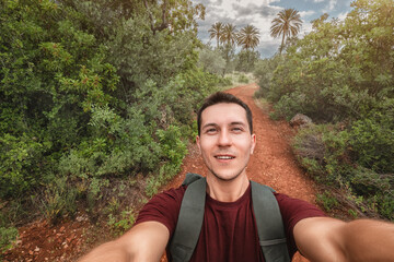 Young happy man takes selfie photo during his awesome hiking trek somewhere in Africa national...