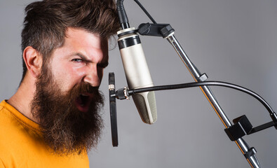 Studio records. Bearded man singing in condenser microphone. Professional vocalist. Karaoke singer.