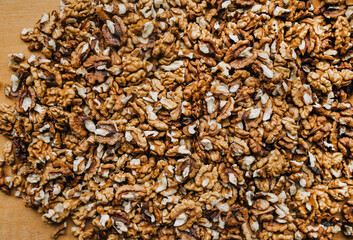 Background, texture of many brown walnuts, shelled nuts lying on the table. Food photography, top view, concept.